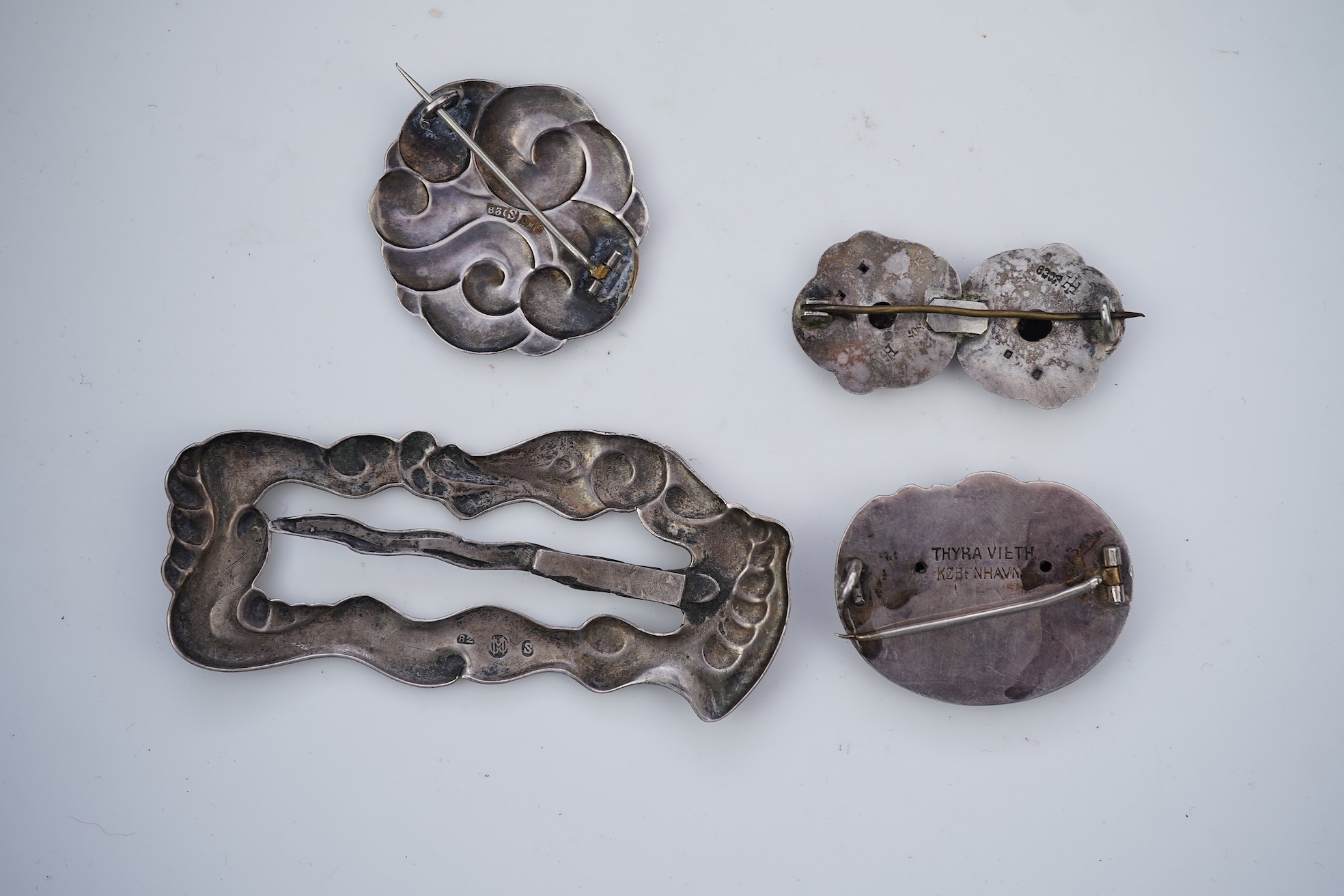 An Arts & Crafts silver slide and three silver brooches, probably Denmark, first half 20th century